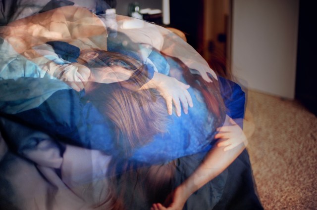 A multiple exposure photograph of a bed in the foreground and a woman tangled in the sheets in various states.